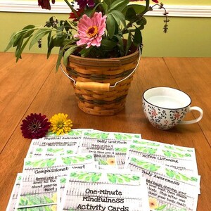 May include: A set of One-Minute Mindfulness Activity Cards with a floral design. The cards feature prompts for activities such as daily gratitude, compassionate heart, active listening, physical awareness, and body awareness.