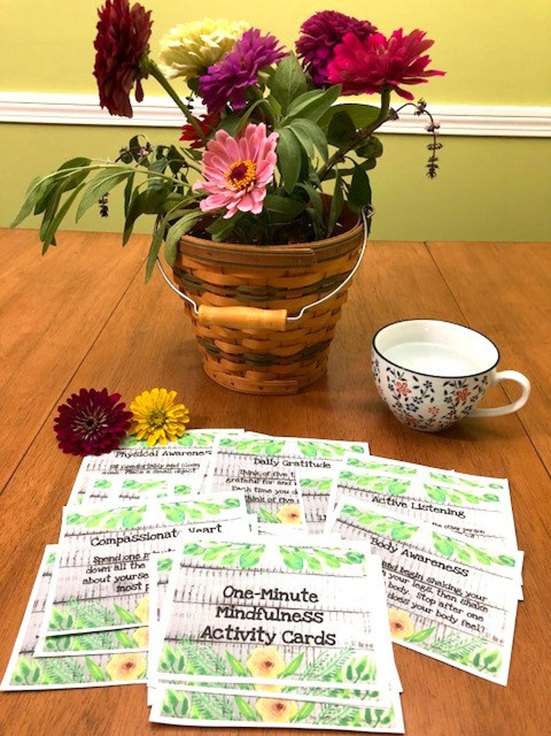 May include: A set of One-Minute Mindfulness Activity Cards with a floral design. The cards feature prompts for activities such as daily gratitude, compassionate heart, active listening, physical awareness, and body awareness.