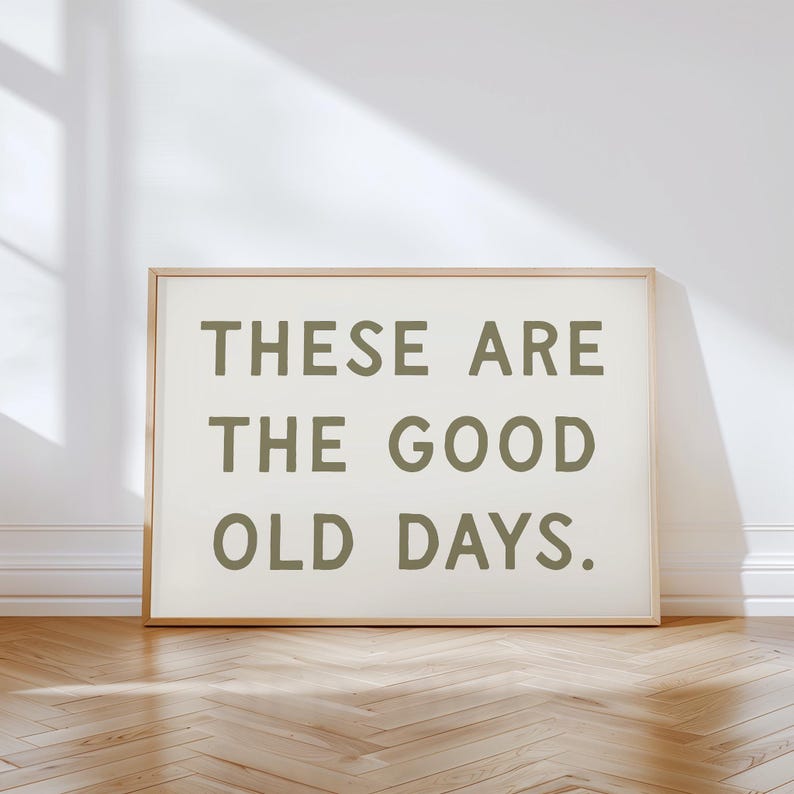 May include: A framed print with the text "These are the good old days." in a dark green color on a white background.