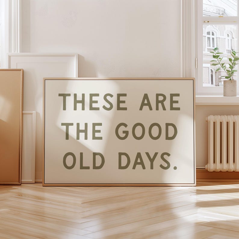 May include: A framed print with the text "These are the good old days." in a dark green color on a white background.