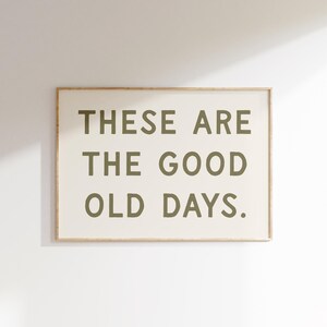 May include: A framed print with the text "These are the good old days." in a dark green color on a white background.