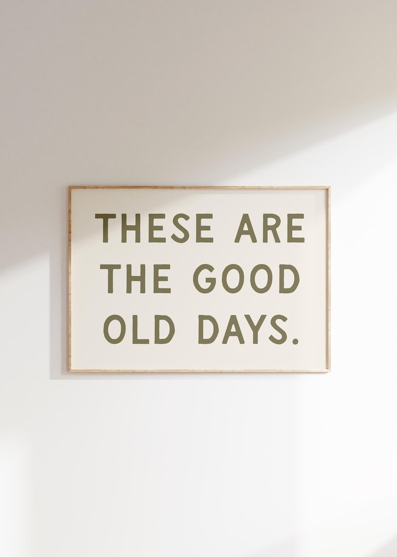 May include: A framed print with the text "These are the good old days." in a dark green color on a white background.