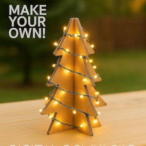 Puede incluir: Un árbol de Navidad de cartón decorado con luces. El árbol está sobre una superficie de madera. El texto "MAKE YOUR OWN!" está en la esquina superior izquierda de la imagen. El texto "DIGITAL DOWNLOAD INSTRUCTIONAL PDF" está en la parte inferior de la imagen.
