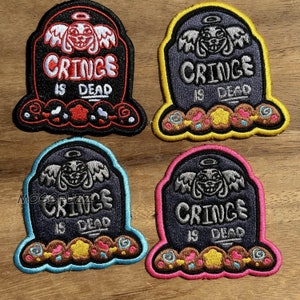 May include: Four embroidered iron-on patches featuring a tombstone with the text "Cringe is Dead" and a cartoon character with angel wings. The tombstones are outlined in black, pink, blue, and yellow.