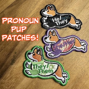 May include: Three embroidered iron-on patches featuring cartoon corgis wearing sweaters with different pronoun sets: "He/They", "She/Her", and "They/Them".