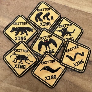 May include: Seven yellow and black warning signs with the text "Critter Xing" and an image of a different creature on each sign. The creatures include a bat, a worm, a slug, a dragon, a beetle, a fox, and a pair of humanoid feet.