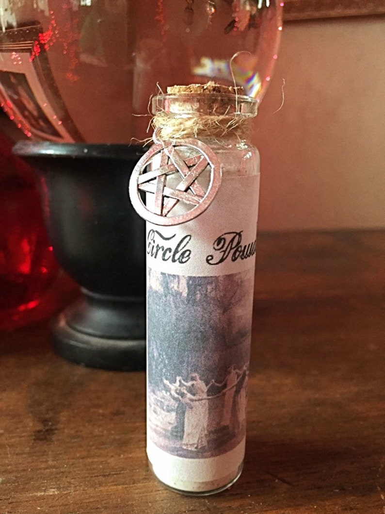 May include: A small glass bottle with a cork stopper and a white label that reads "Circle Power". The bottle is tied with twine and has a silver pentagram charm attached.