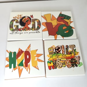 May include: Four square ceramic coasters with inspirational messages and graphics. One coaster reads "With God all things are possible" with a woman's profile. Other coasters say "Love", "Hope", and "Built by Black History".