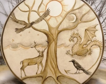May include: A circular wooden drum with a painted design of a tree with a sun, moon, deer, bird, and dragon. The tree is brown, the sun is orange, the moon is white, the deer is brown, the bird is black, and the dragon is brown.