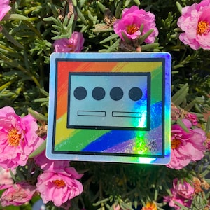 May include: A rainbow-colored sticker with a white border and a gray rectangle inside. The rectangle has three black circles and two gray lines. The sticker has the text "#radicalmutant" at the bottom.