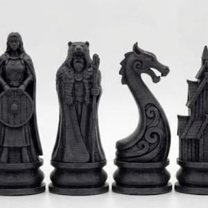 May include: A black Viking-themed chess set. The pieces depict a king, queen, bear, dragon, church, and warrior. Each piece is on a round base. The set is made of a dark material, with each piece measuring approximately 7-10 cm in height.