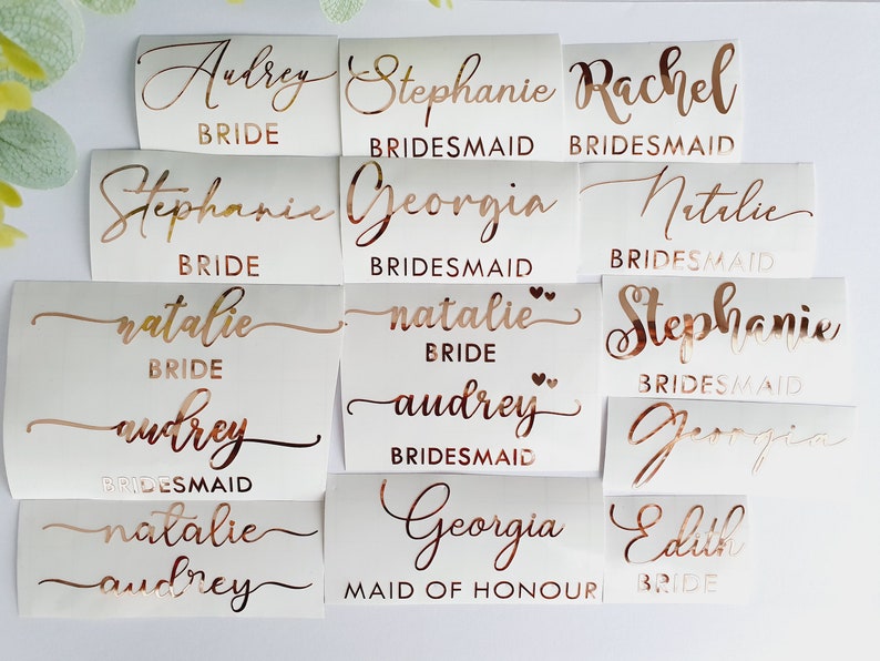 K&ouml;nnte beinhalten: Ein Satz mit 12 Aufklebern aus ros&eacute;goldener Folie mit Namen und Titeln f&uuml;r eine Hochzeitsgesellschaft. Die Namen sind Audrey, Stephanie, Rachel, Georgia, Natalie und Edith. Die Titel sind Braut, Brautjungfer und Maid of Honor.