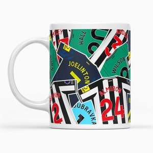 Pode incluir: Caneca de cer&acirc;mica branca com um padr&atilde;o listrado preto e branco e patches coloridos com nomes e n&uacute;meros de jogadores de futebol, incluindo "Joelinton", "Almiron", "Dubravka" e "Wilson".