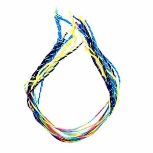 以下が含まれることがあります： 青、黄色、赤の色合いのカラフルな編み紐の集まり。紐はねじり合わせて、装飾的でユニークなデザインになっています。