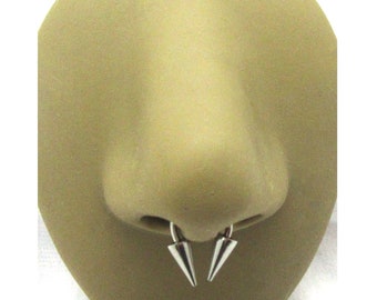 May include: A close-up of a nose piercing with two silver spikes. The piercing is 8mm in size.