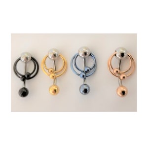 Puede incluir: Cuatro piercings para el ombligo en negro, dorado, azul y oro rosa. Cada uno presenta una bola superior plateada, un diseño de doble aro y bolas más pequeñas colgantes y una bola inferior más grande. Los anillos se muestran sobre un fondo blanco.