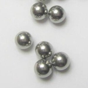 May include: A group of silver-colored metal balls. The balls are smooth and round.