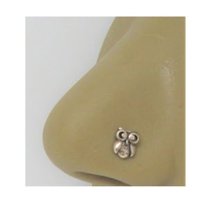 May include: Silver nose ring with an owl design.