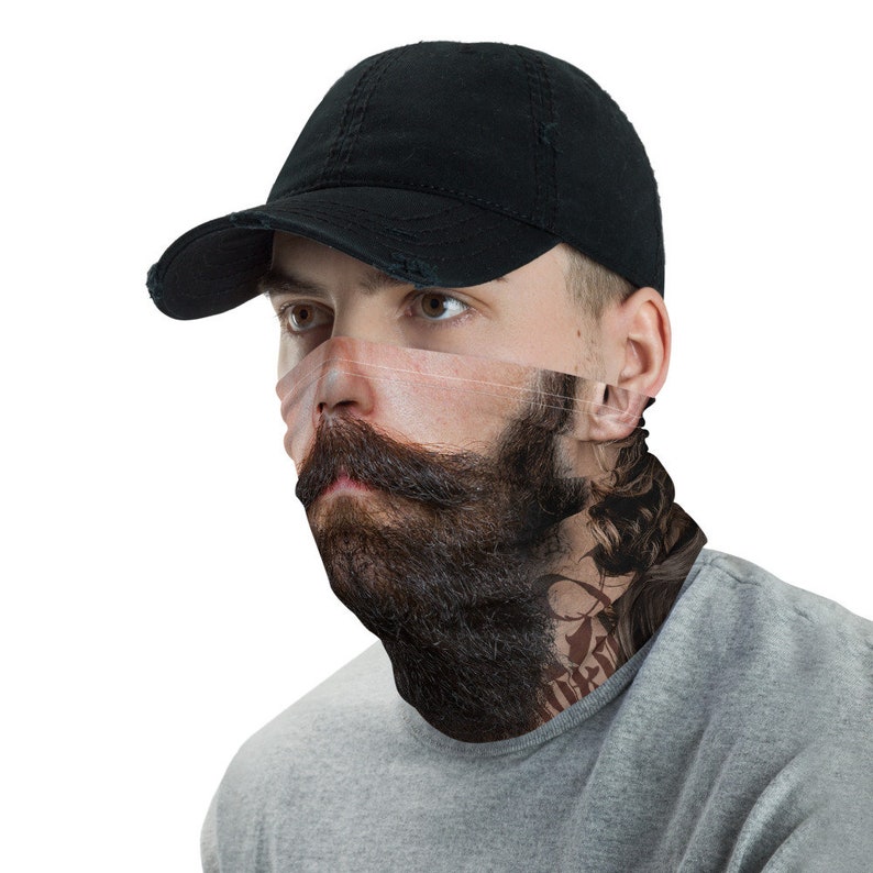 May include: A black baseball cap with a face mask featuring a bearded man with a tattoo on his neck. The mask is printed with a realistic image of a man's face.