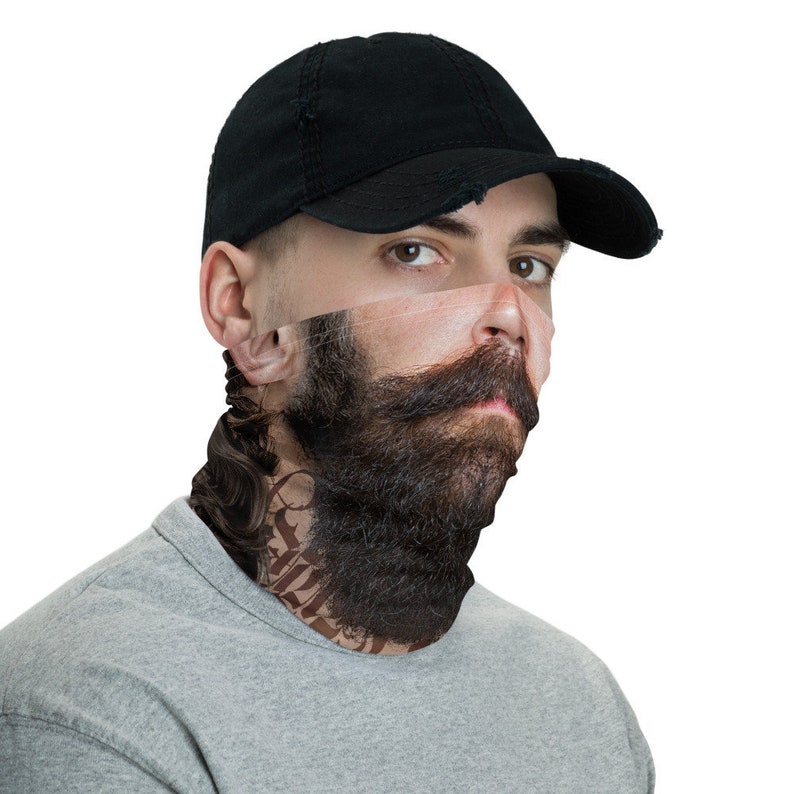 May include: A black baseball cap with a distressed look is worn by a person wearing a face covering. The face covering is a printed design of a man with a beard and a tattoo on his neck.