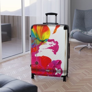 Abstract art hard shell suitcase featuring vibrant splashes of pink, red, yellow, orange, and blue on a glossy white background. Modern spinner luggage for creative travelers, perfect as a gift for artists and color lovers. Stylish carry-on suitcase with bold, unique painting-inspired design, ideal for holidays, business trips, and fashion-forward journeys. Durable, lightweight case blends contemporary aesthetics with bright pop art energy for men and women.