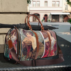 Könnte beinhalten: Eine braune Ledertasche mit einem Schwarz-Weiß-Druck von Frauen und einem Panther. Die Tasche hat einen langen verstellbaren Riemen und einen oberen Griff.