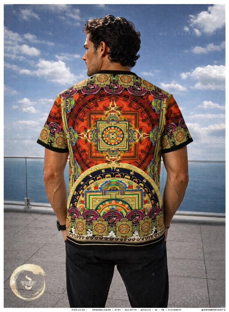 May include: A short-sleeved t-shirt featuring a vibrant, intricate mandala-inspired print in shades of orange, red, gold, and purple. The design includes geometric patterns and circular motifs across the back and sleeves, finished with a black trim.