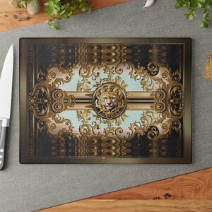 May include: Rectangular cutting board with a decorative design. The board features a gold and black baroque pattern with a central light blue stripe and a gold cheetah emblem. The board is surrounded by a dark brown border.