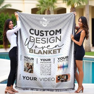 May include: A gray woven blanket with the text "Custom Design Woven Blanket" and the words "Your Photo", "Your Message", "Your Voice", and "Your Video" in boxes. Two women are holding the blanket.