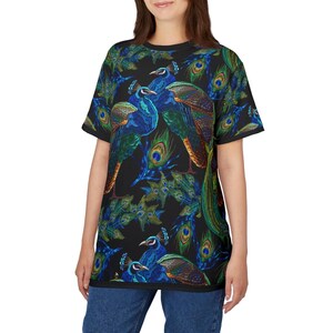 May include: Black t-shirt featuring a vibrant peacock design. The shirt showcases detailed illustrations of peacocks with blue, green, and gold feathers. The design is repeated across the fabric, creating a bold, eye-catching pattern.