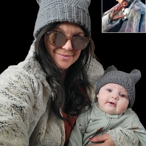 Può includere: Un berretto grigio all'uncinetto con orecchie da gatto. Il cappello è indossato da una persona e da un bambino. La persona indossa occhiali da sole e un cappotto di finta pelliccia. Il bambino indossa una tutina verde. Un'immagine più piccola di una persona con lo stesso cappello è nell'angolo in alto a destra.