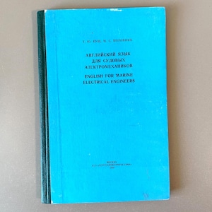 Puede incluir: Un libro turquesa titulado "English for Marine Electrical Engineers". La portada presenta texto en inglés y ruso. El lomo del libro es de color verde oscuro. Es un manual para ingenieros eléctricos marinos.