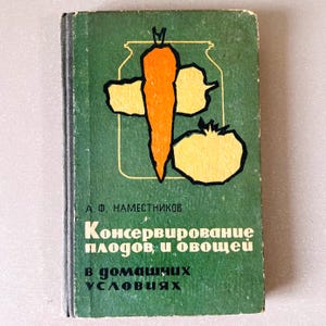 May include: Vintage book with a green cover featuring a colorful illustration of a carrot, tomato, and jar. The title, in Russian, reads "Canning of Fruits and Vegetables at Home."