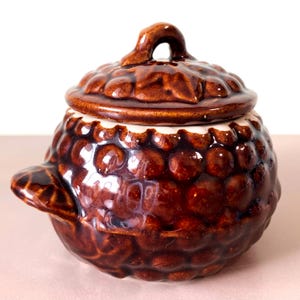 Könnte beinhalten: Rustikales Holzschild mit dem weißen Schriftzug "Welcome to our home". Das Schild hat ein verwittertes Finish und ein schlichtes Design, ideal für die Dekoration des Eingangs.