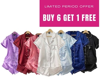 May include: Six pairs of satin pyjamas in various colours, including lavender, red, pink, white, light blue, and black. Each pair has a short-sleeved top with a button-down collar and matching shorts. The tops feature embroidered initials. The text "LIMITED PERIOD OFFER BUY 6 GET 1 FREE" is displayed at the top of the image. The text "Free Shipping for orders above £35" is displayed at the bottom of the image.