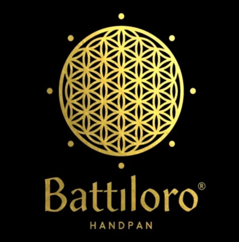 Puede incluir: Un logotipo dorado con un patr&oacute;n geom&eacute;trico que se asemeja a una flor de la vida. El texto "Battiloro" est&aacute; debajo del patr&oacute;n, con la palabra "HANDPAN" en letras m&aacute;s peque&ntilde;as debajo del texto.