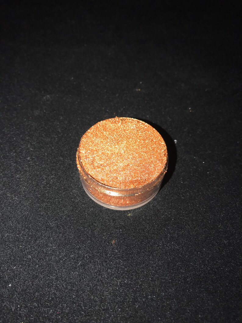 May include: A small round jar filled with fine gold glitter.