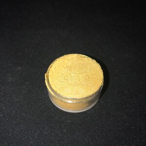 May include: A small clear jar filled with gold glitter.