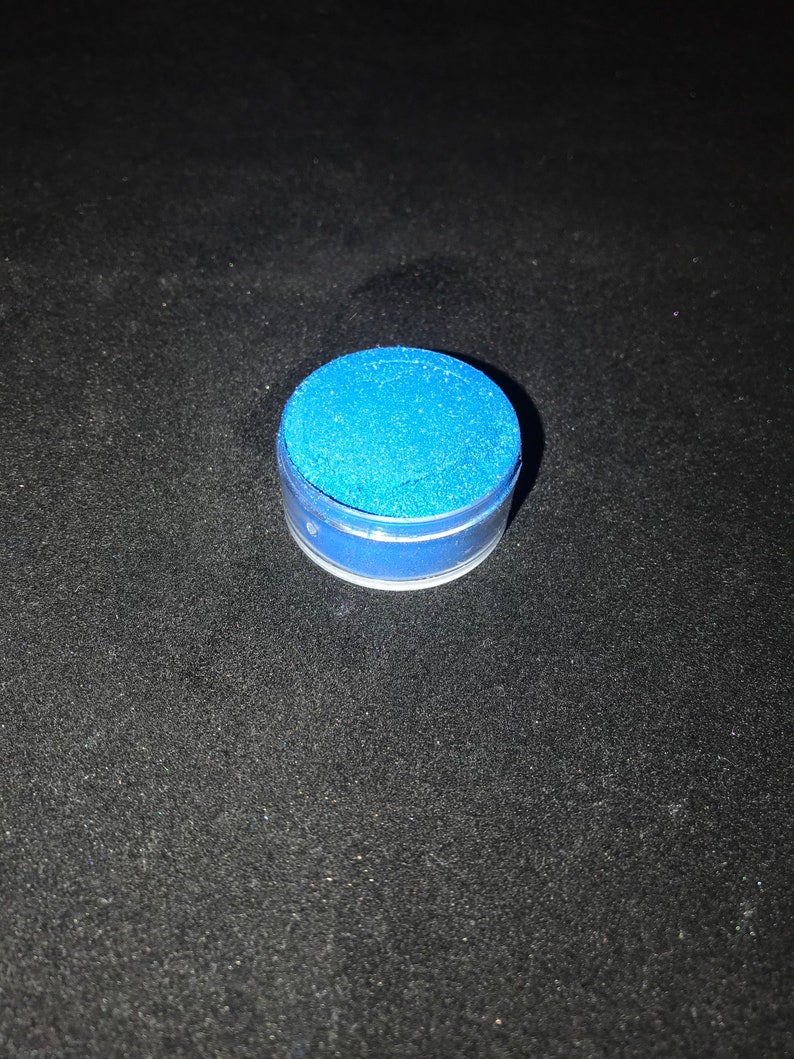 May include: A small round container of blue glitter.