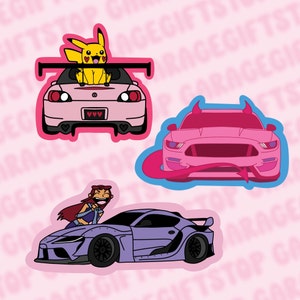 May include: Three car stickers featuring a pink Honda Civic with a yellow Pikachu character, a pink Ford Mustang with devil horns, and a purple Toyota Supra with a cartoon woman character.