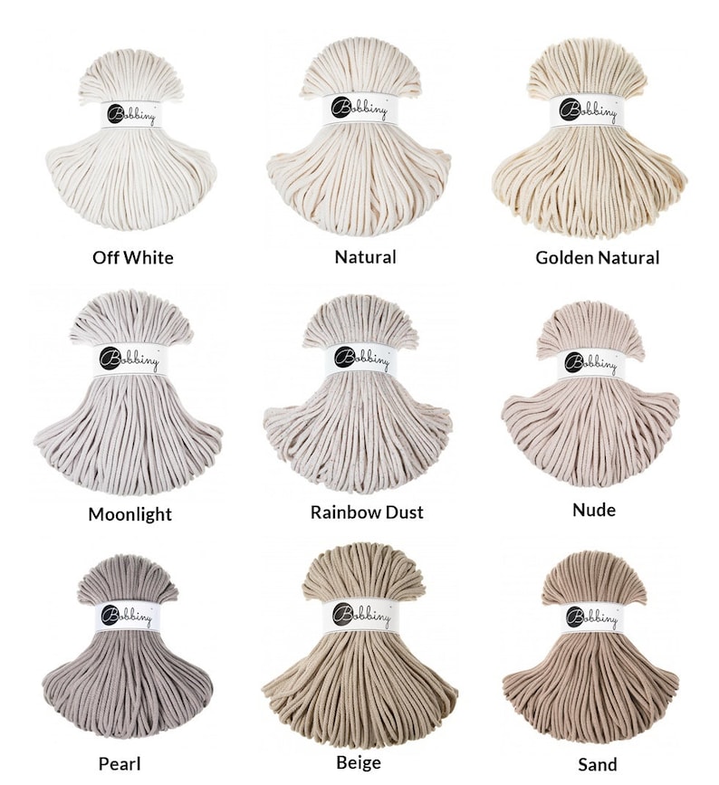 Puede incluir: Nueve carretes de cuerda de algod&oacute;n en varios tonos de blanco, beige y marr&oacute;n. Los carretes est&aacute;n dispuestos en tres filas de tres. Los colores est&aacute;n etiquetados: Blanco roto, Natural, Dorado natural, Luz de luna, Polvo de arco&iacute;ris, Desnudo, Perla, Beige y Arena.