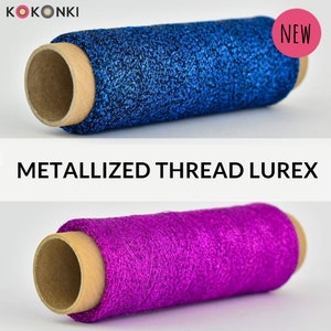 Op de afbeelding: Twee spoelen met metallic garen, een blauwe en een paarse, met de tekst "NEW" en "METALLIZED THREAD LUREX" op de afbeelding.
