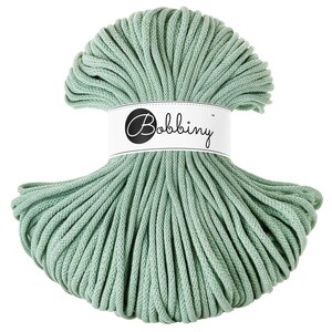 May include: A spool of light green cotton rope, labeled "Bobbiny" in black text on a white label.