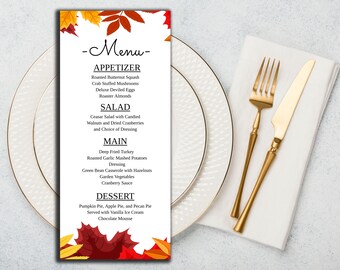 Può includere: Un menu verticale con sfondo bianco e illustrazioni di foglie autunnali colorate in alto e in basso. Il testo elenca le sezioni Appetizer, Salad, Main e Dessert con vari piatti stampati in un carattere serif di colore nero.