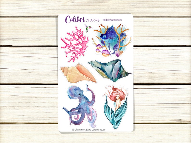 May include: A sheet of stickers featuring watercolor illustrations of a seashell, a mermaid, an octopus, a coral, and a fish. The stickers are labeled "Enchantment Extra Large Images" and "Colibri Charms".