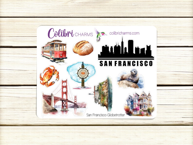 May include: A sheet of stickers featuring various San Francisco landmarks, including the Golden Gate Bridge, a cable car, a sourdough loaf, and a sea lion. The stickers are printed on white paper with a watercolor-style design. The text "San Francisco Globetrotter" is printed at the bottom of the sheet.