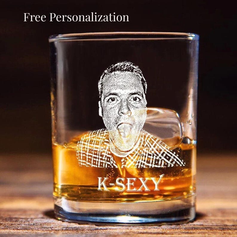 This picture shows an 11 ounce personalized whiskey bourbon glass that is engraved with a picture of a young man.  Text is engraved under the photo which reads K-Sexy.