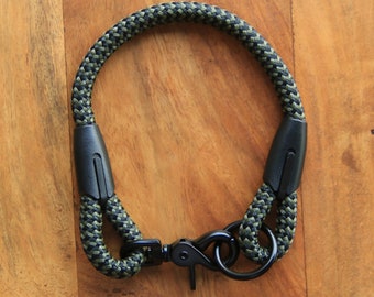 May include: A black and green rope dog collar with a black metal clip.