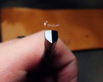 May include: A metal leathercraft edge beveler tool featuring a polished, angled cutting tip with a distinct V-shaped groove. The tool is marked with the text TroyLab and two small star icons, showcasing a metallic finish and a sharp, precise edge.