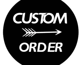 May include: A circular black sign featuring the white text CUSTOM at the top and ORDER at the bottom, separated by a horizontal white arrow graphic pointing to the right, centered within the black circle.